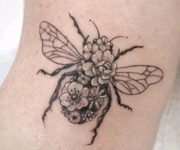 a bee with flowers on it's back leg