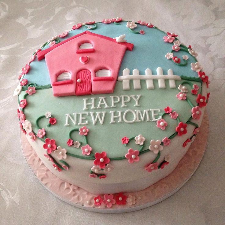 a birthday cake decorated with flowers and a house on the top that says happy new home