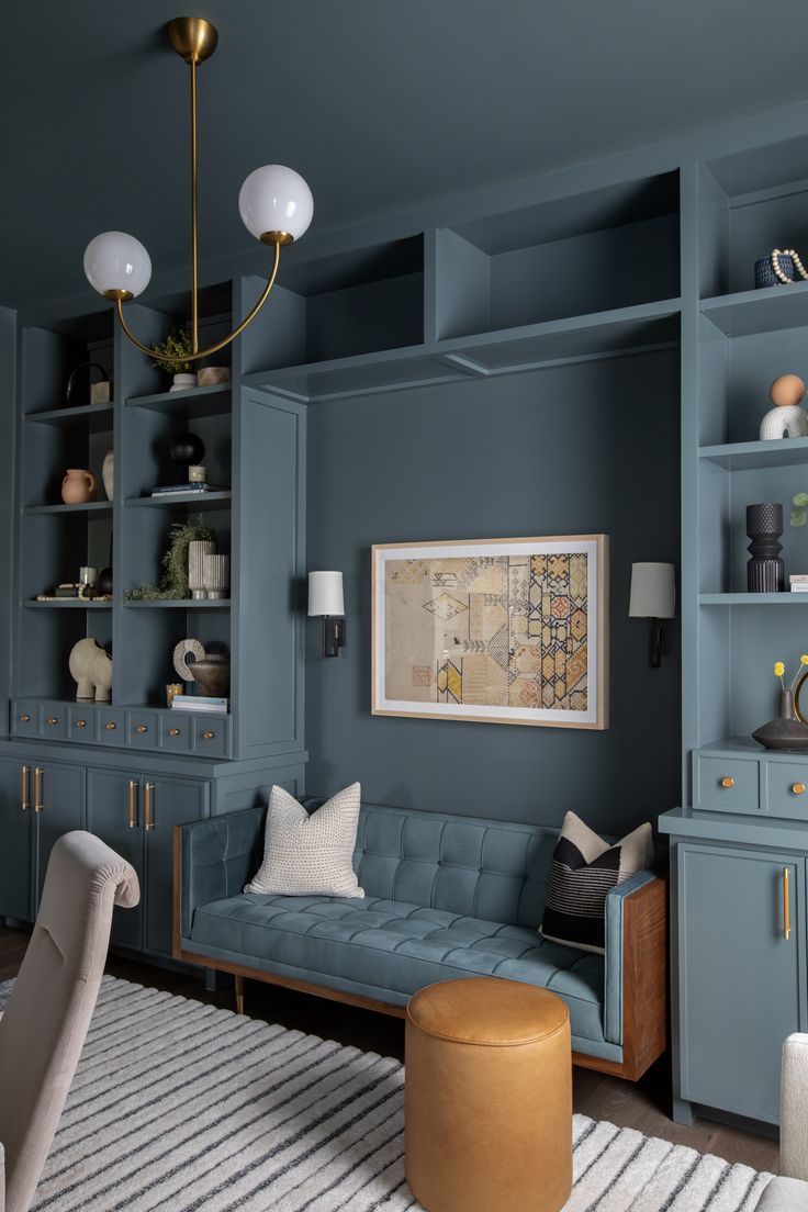 a living room with blue walls and shelves on the wall, a white rug in front of it