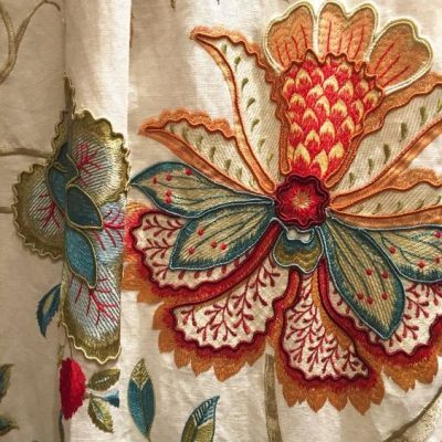 an embroidered fabric with flowers and leaves on it