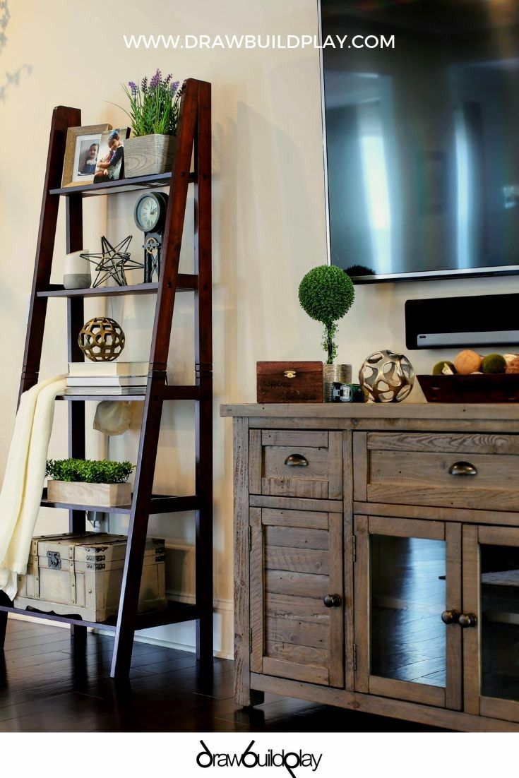 a wooden ladder leaning against a wall in front of a flat screen tv and entertainment center