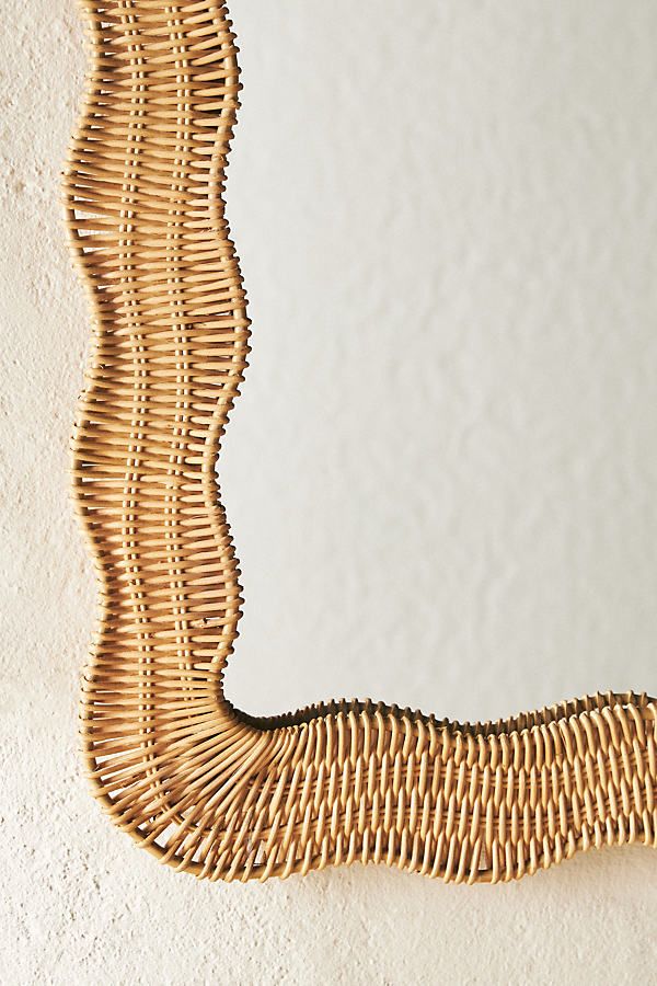 a wicker mirror hanging on the wall