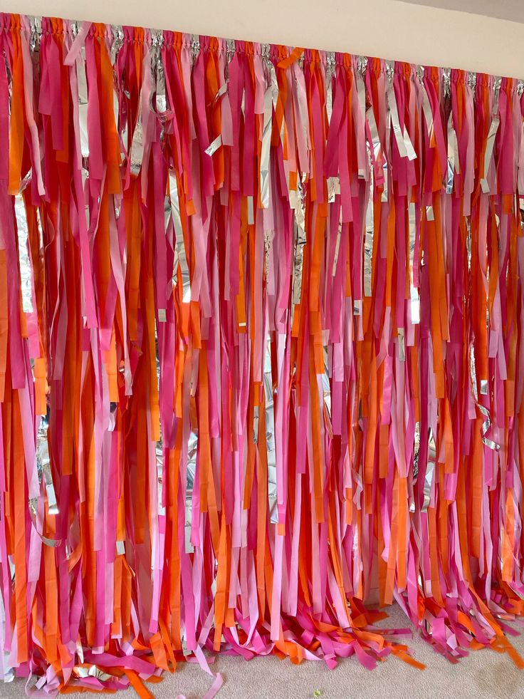 pink and orange streamers are hanging on the wall