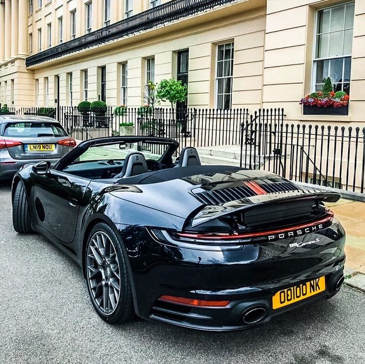 a black sports car parked in front of a building