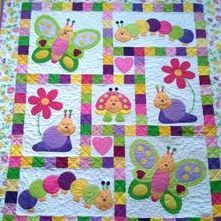 a colorful quilt with butterflies and flowers on it