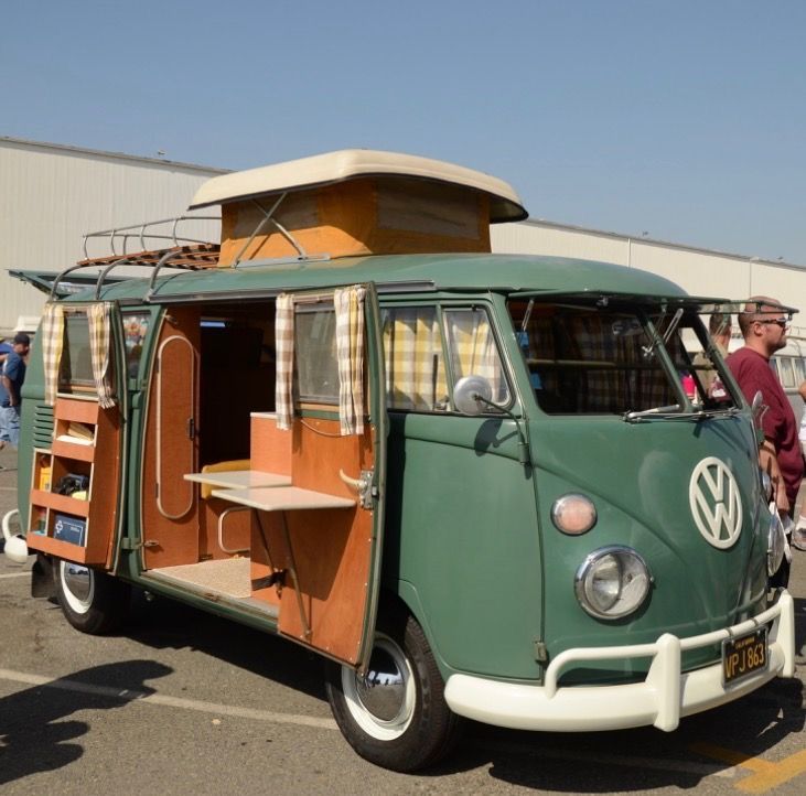 an old vw bus is parked in a parking lot