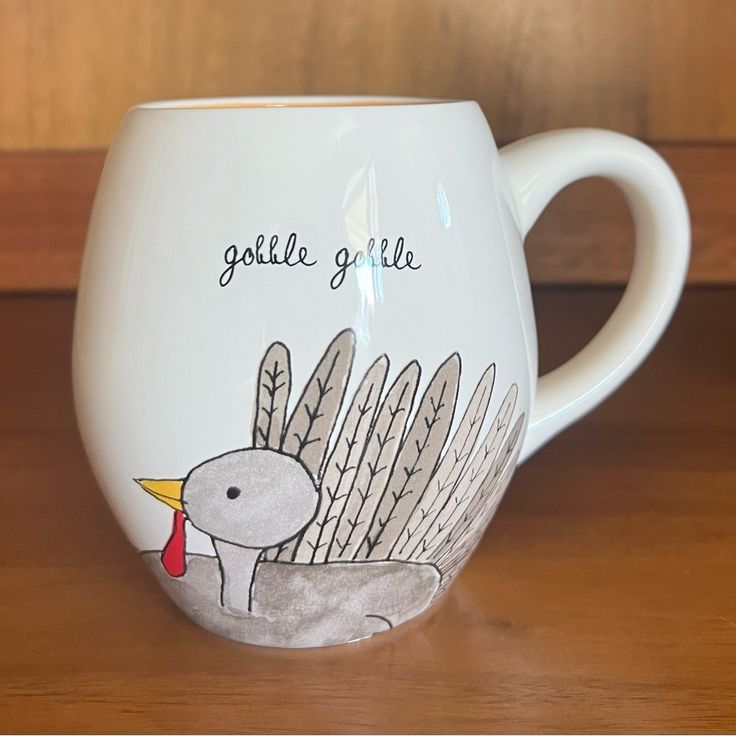 a white coffee cup with an image of a bird on the side and words golle giraffe