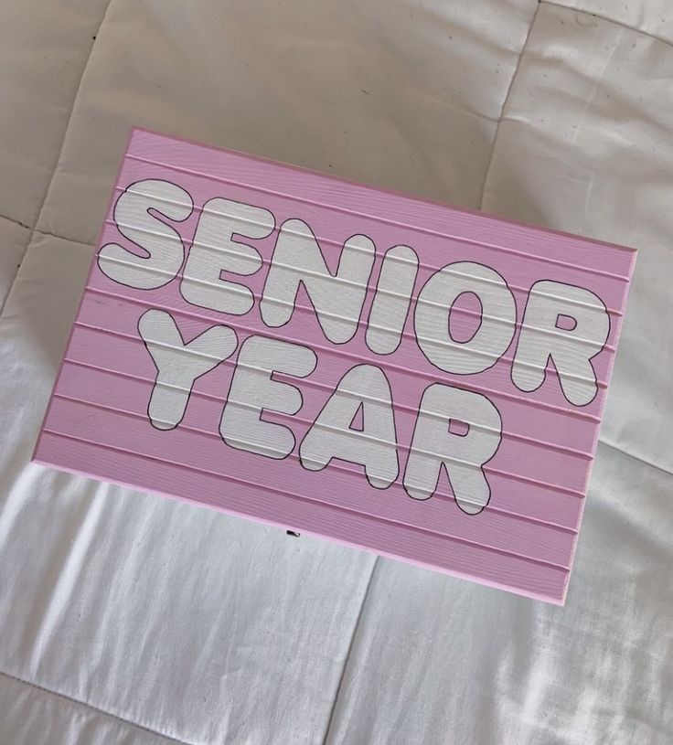 a pink sign that says senior year on it's side with the words,