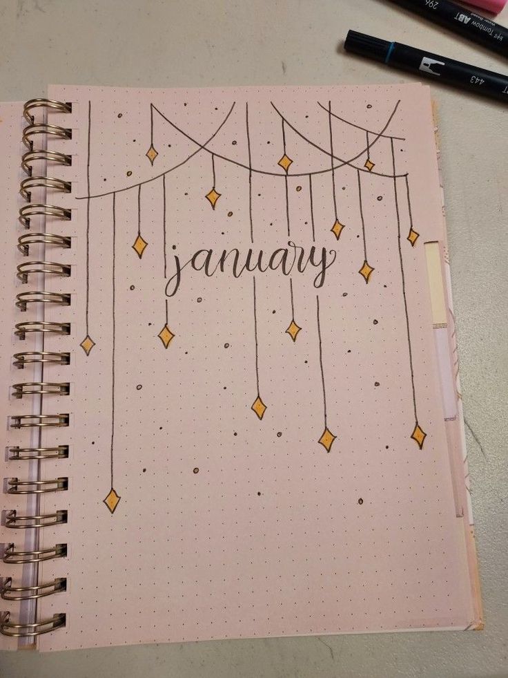 a notebook with the word january written on it next to some markers and pencils