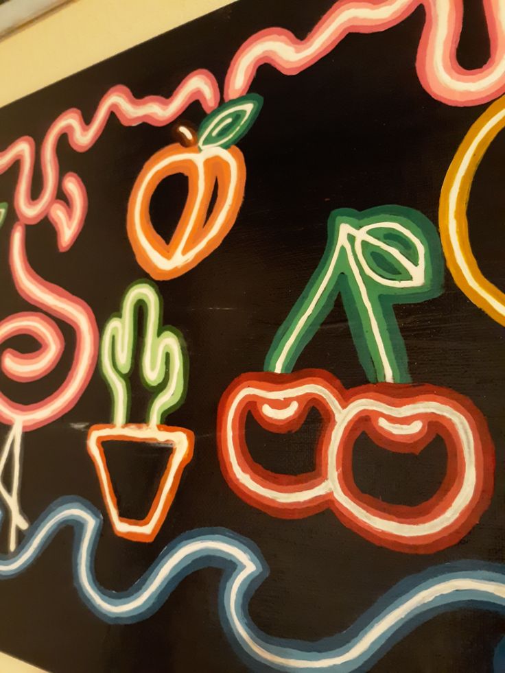 a chalk board that has some fruit and vegetables painted on it with neon lights in the shape of letters