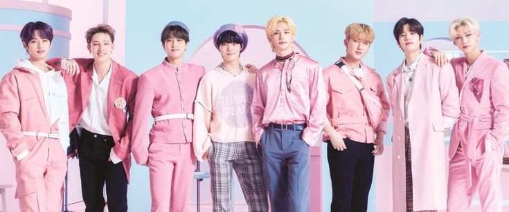 a group of young men standing next to each other in pink outfits and black pants