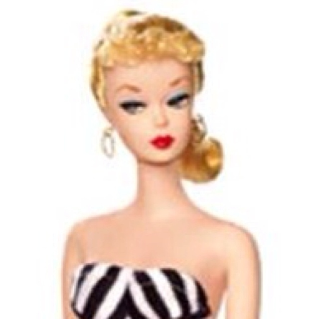 a barbie doll wearing a black and white dress with stripes on it's chest