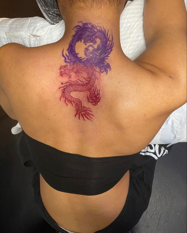 a woman with a dragon tattoo on her back