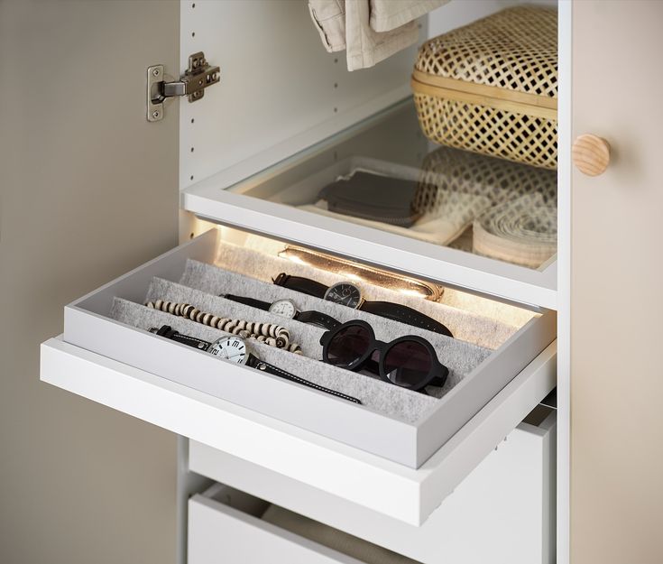 an open drawer with sunglasses and other items in it