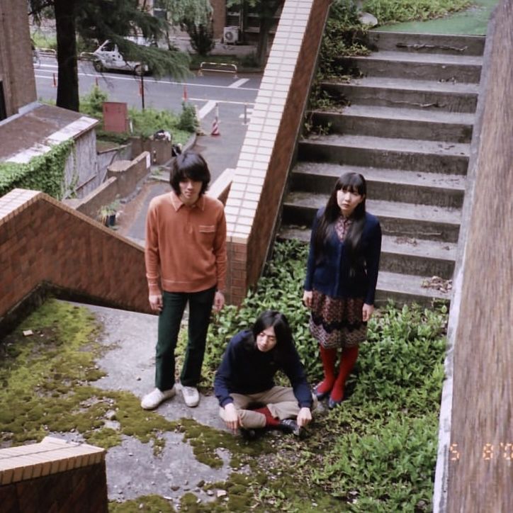 three people standing on the ground near some stairs