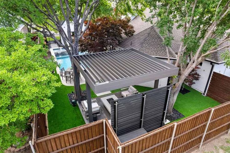 an aerial view of a house with a pool in the back yard and fence surrounding it