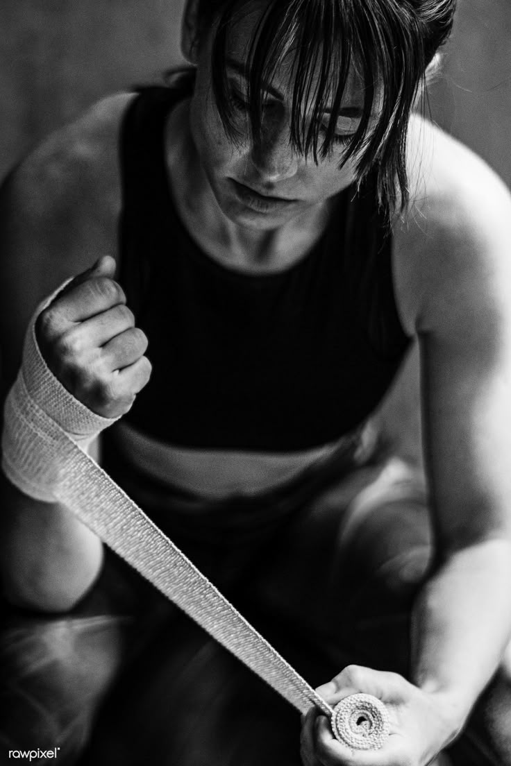 black and white photograph of a woman with bandages on her arm holding a knife in one hand