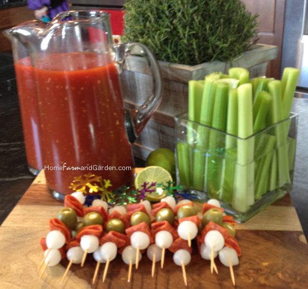 several skewered food items on a wooden table next to a pitcher of juice