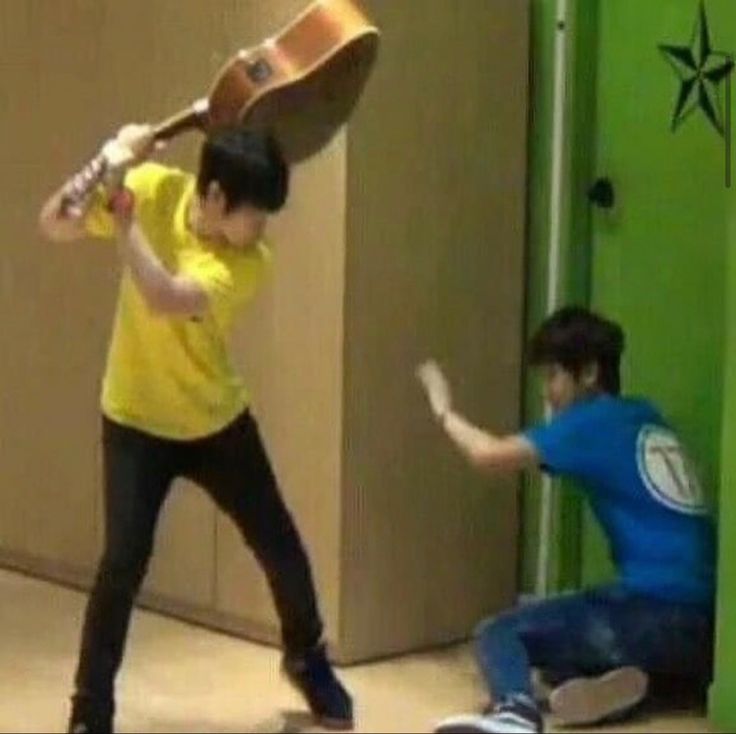 two people in a room with one holding a guitar