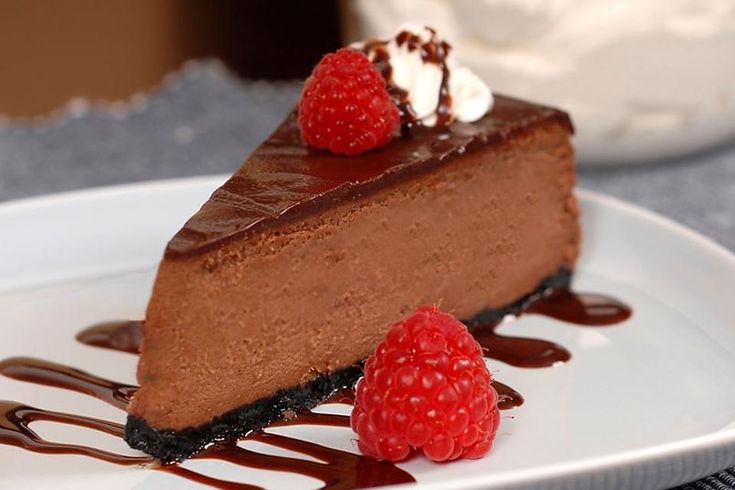 a slice of chocolate cheesecake with raspberries on top