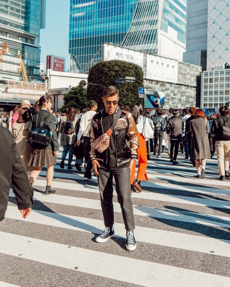 a man standing in the middle of a crosswalk with lots of people behind him