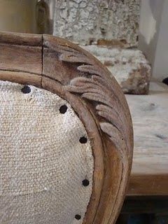 an old wooden chair with white upholstered fabric