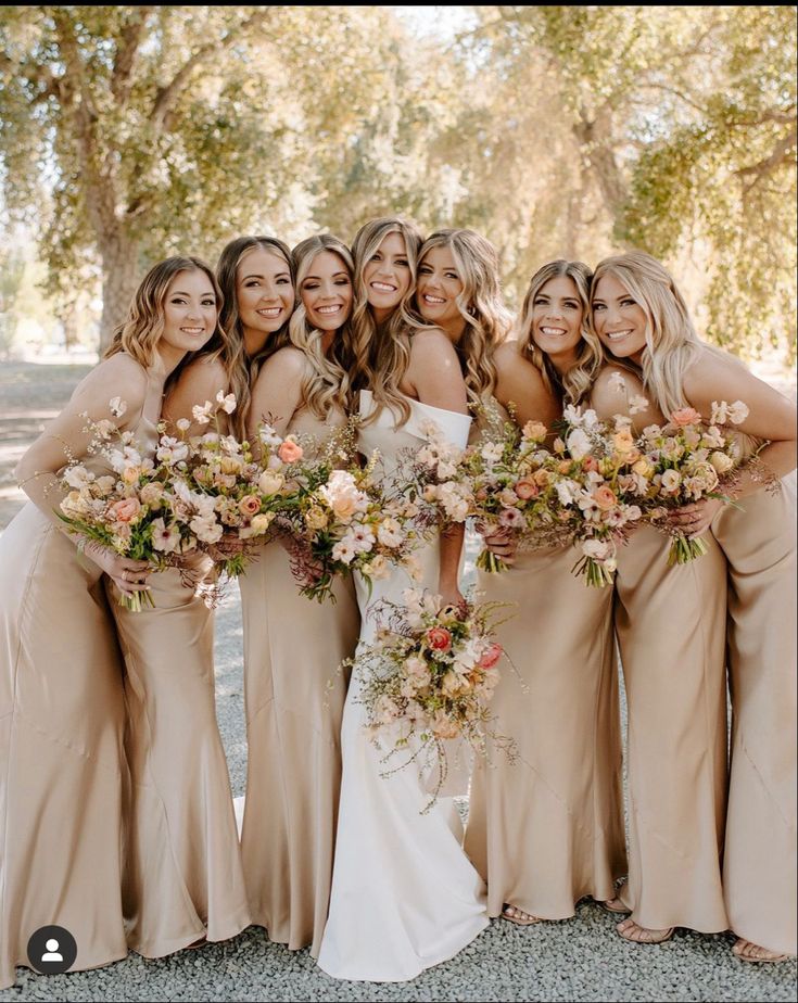 a group of women standing next to each other holding bouquets