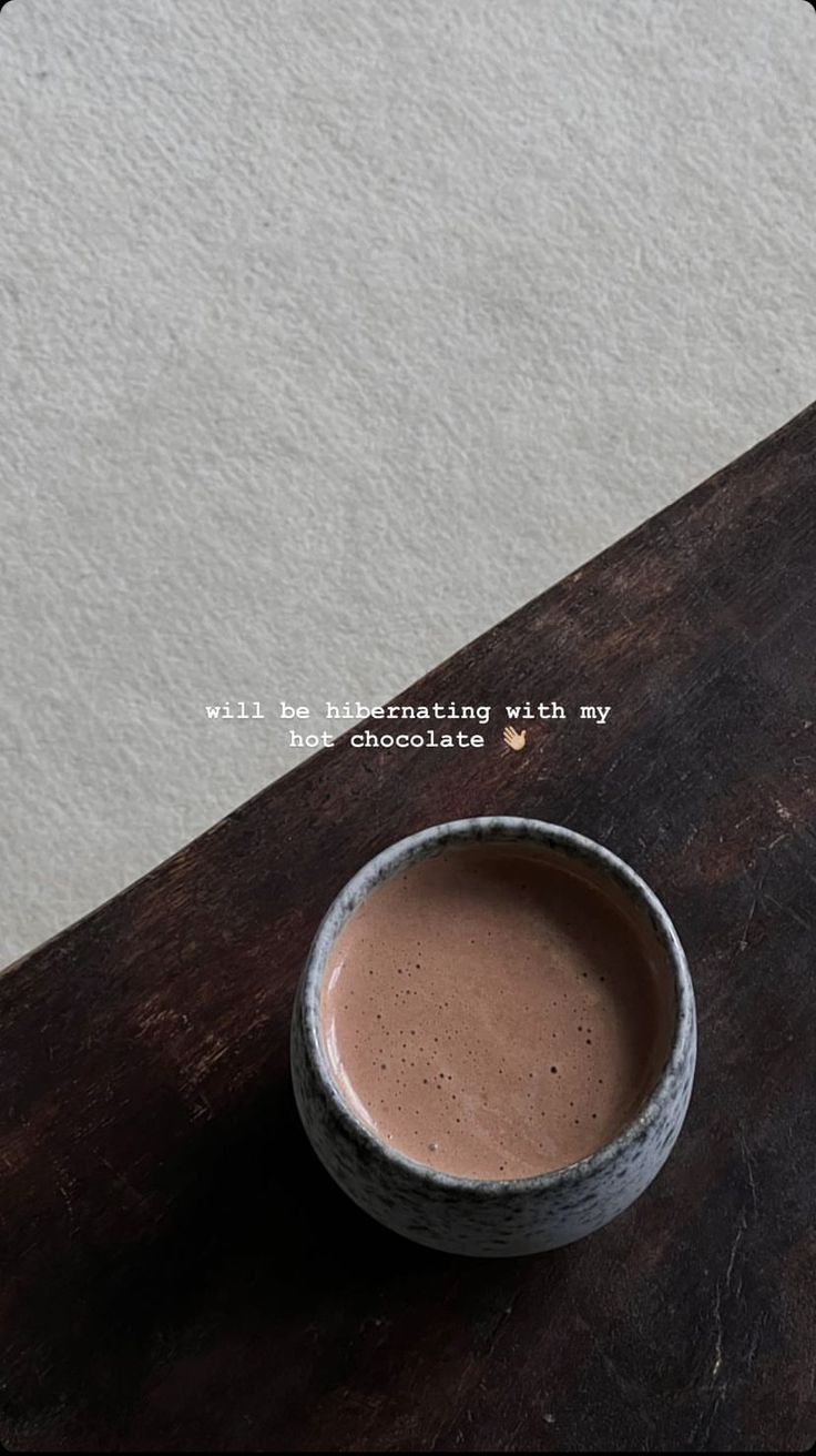 a cup of chocolate sitting on top of a wooden table