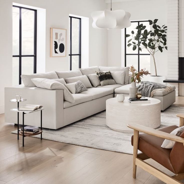 a living room filled with furniture and large windows