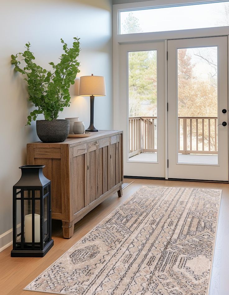 a living room with a large rug and two lamps on either side of the door