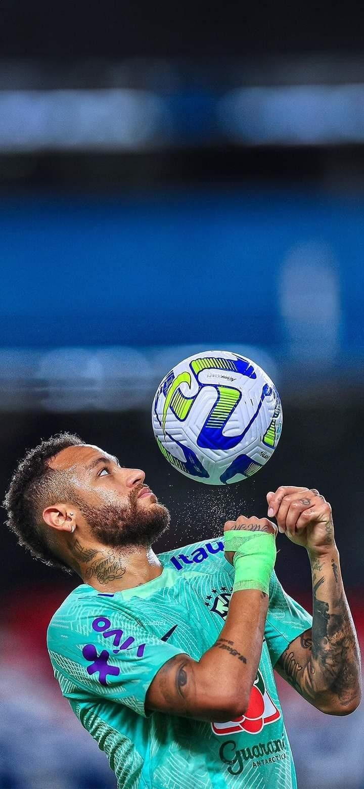 a man in green shirt playing with a soccer ball on top of his head,