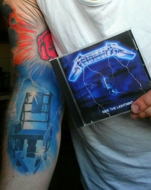 a man with tattoos holding up a cd in front of his arm and shoulder tattoo