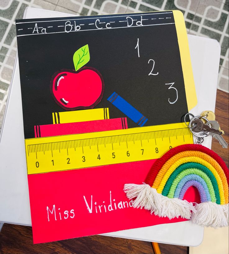 an apple, ruler, and rainbow are on top of a piece of paper that says miss viridda