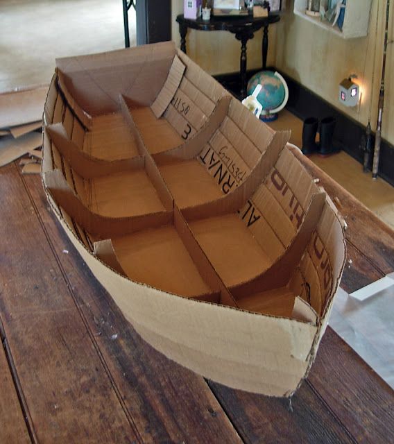 a cardboard boat sitting on top of a wooden table