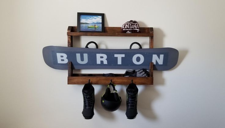 a snowboard mounted to the side of a wall with two boxing gloves hanging from it