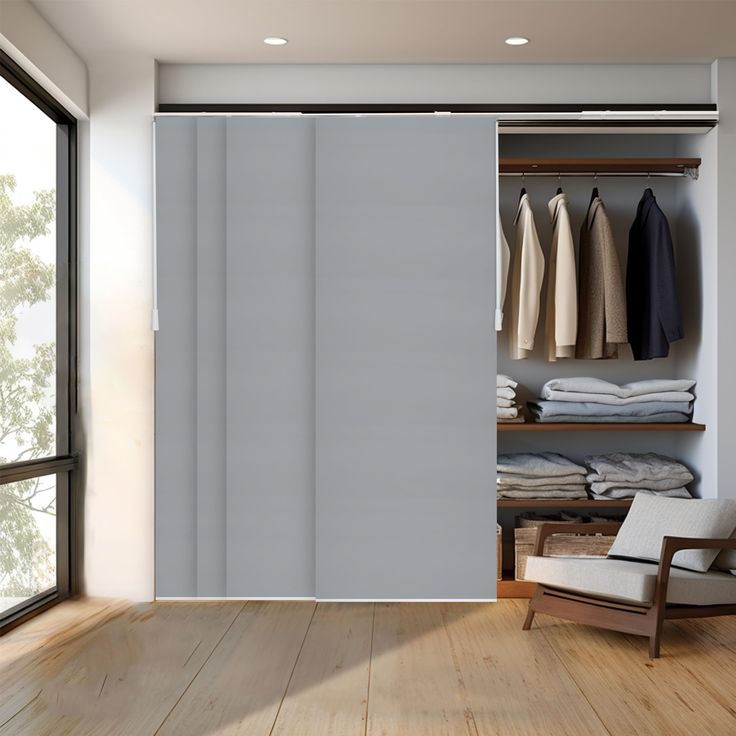 an open closet with clothes on hangers and a chair