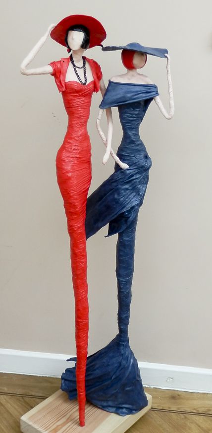 two mannequins dressed in blue and red, one with a hat on her head