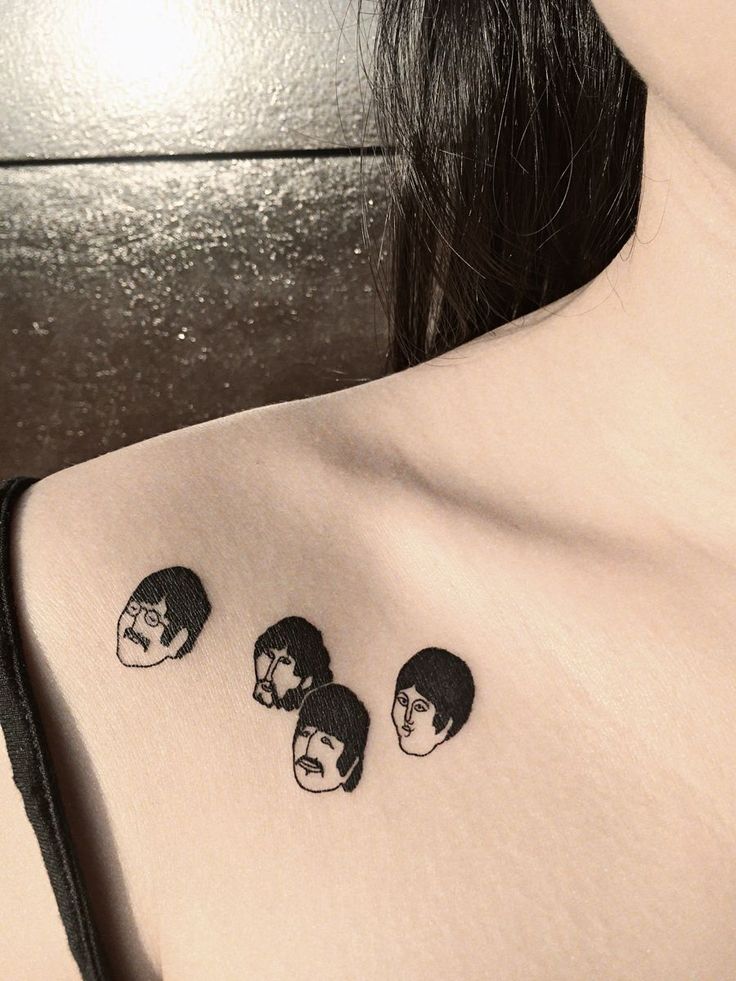 the beatles tattoo on the back of a woman's left shoulder is black and white