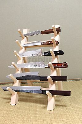 a knife holder made out of wood with several knives on the top and one in the middle