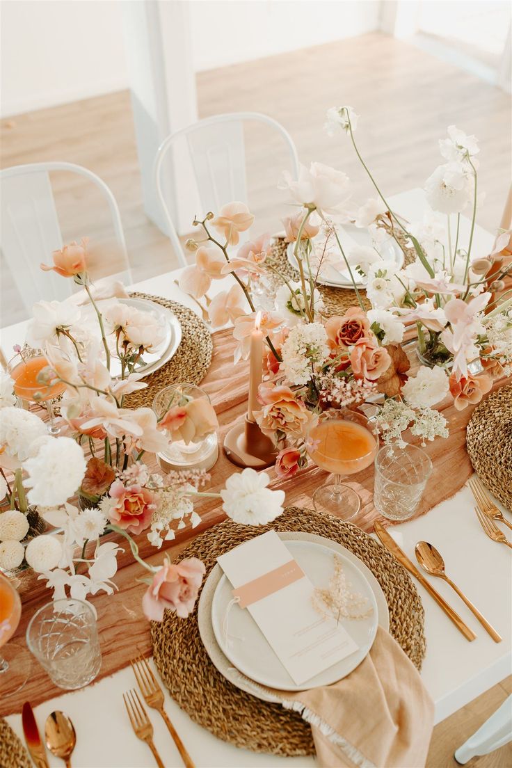 the table is set with flowers and place settings