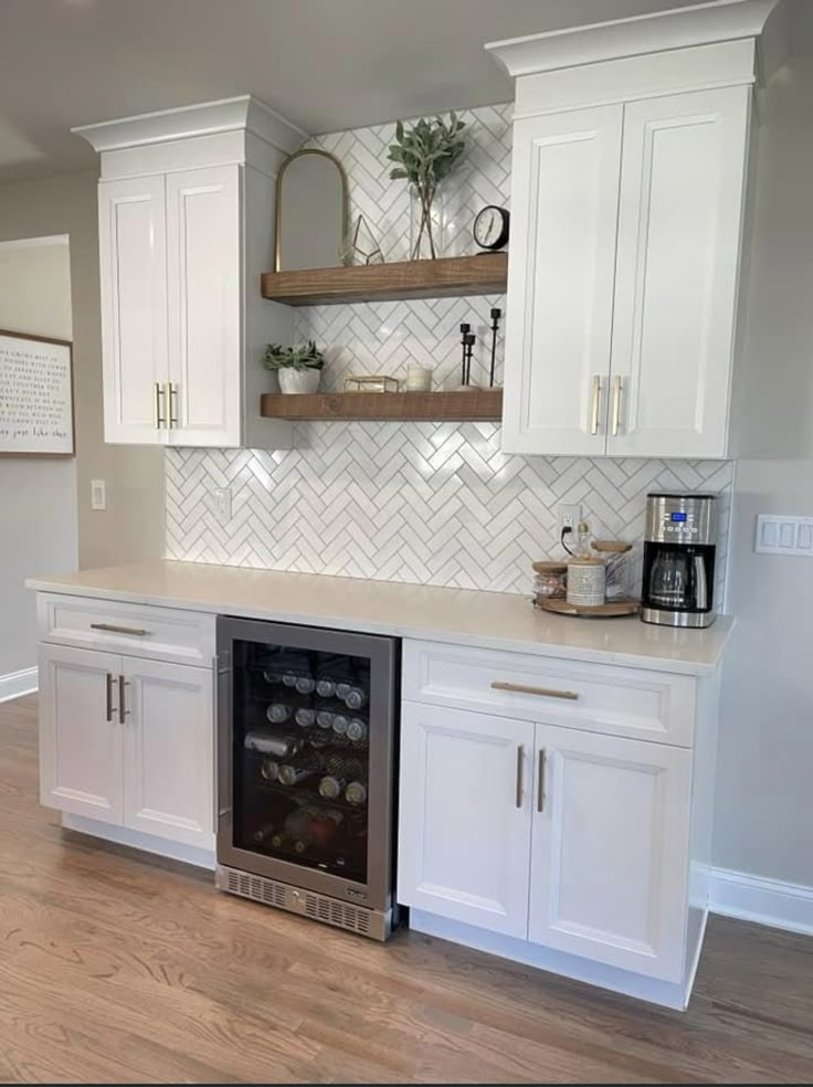 a kitchen with white cabinets and a wine cooler