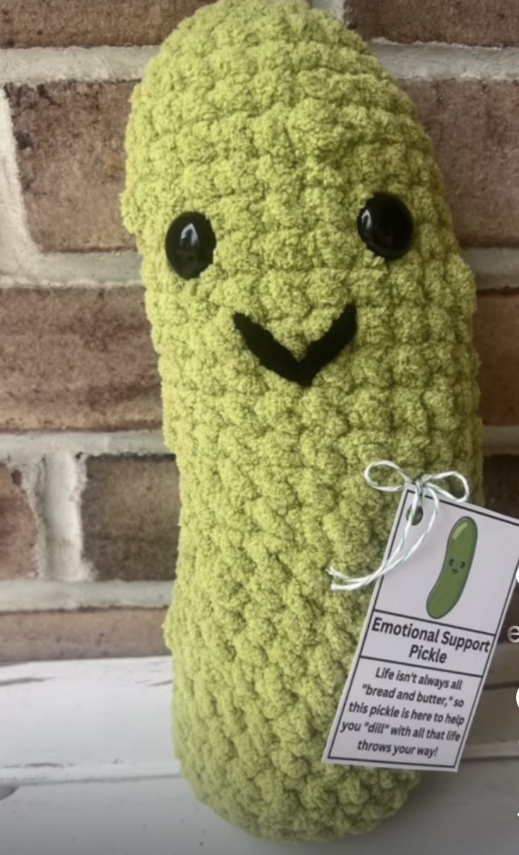 a crocheted pickle stuffed animal with a tag on it's ear