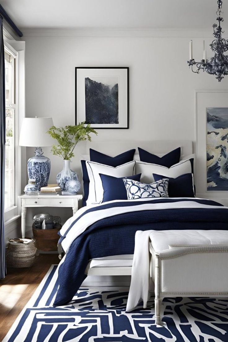 a bedroom with blue and white decor on the walls, bed linens in dark blue and white