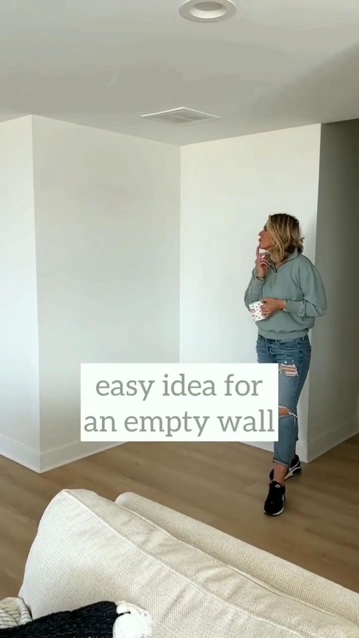 a woman standing in an empty room with the words easy idea for an empty wall