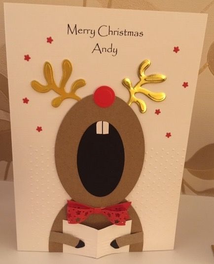 a christmas card with a reindeer head and antlers on it's face, reading a book