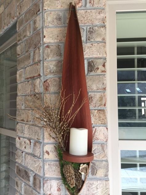 a candle sits on a shelf next to a brick wall