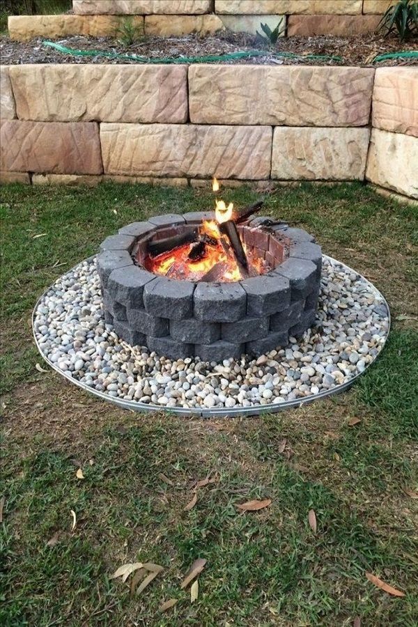 a fire pit sitting on top of a lush green field