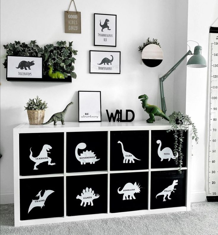 a white and black dresser with dinosaur silhouettes on it