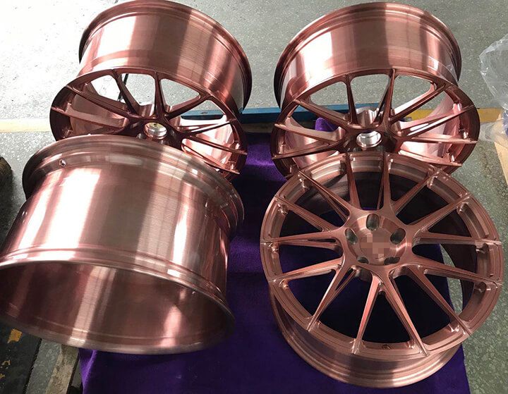 some copper colored wheels are sitting on a purple table