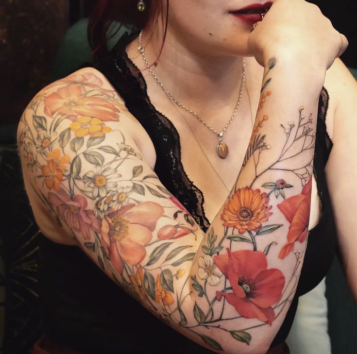 a woman with red hair and tattoos on her arm